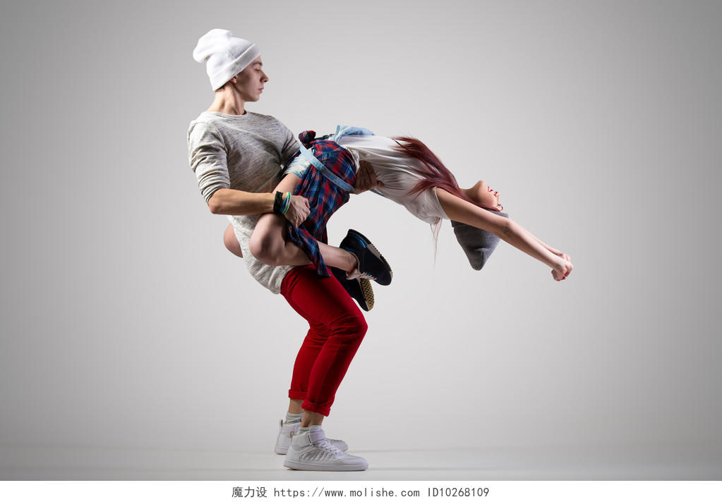 灰色背景上两个现代风格的漂亮舞蹈家在表演活力青春活力